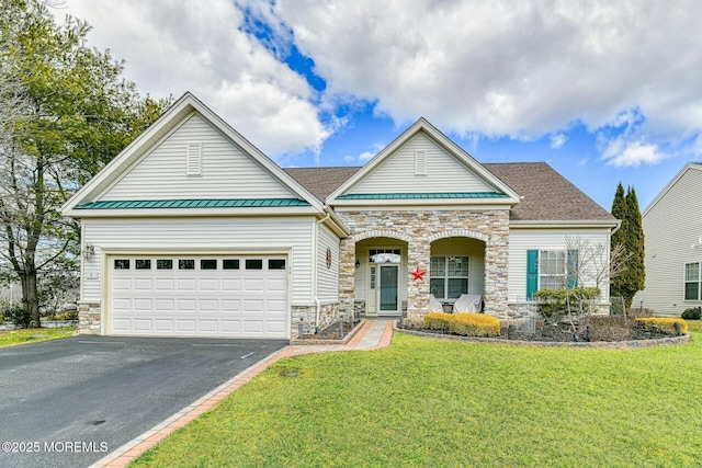 view of front of home with a porch, a front yard, a garage, stone siding, and driveway