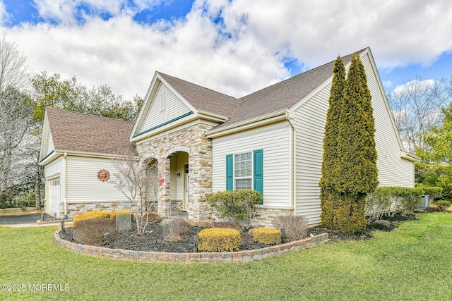 view of front of property with stone siding, a front lawn, an attached garage, and a shingled roof