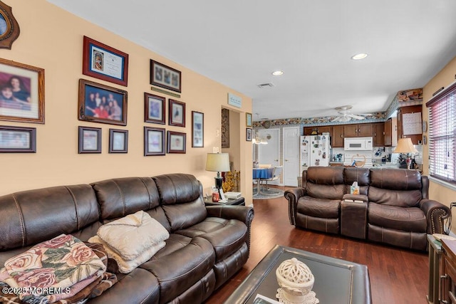 living room with visible vents, dark wood finished floors, and recessed lighting