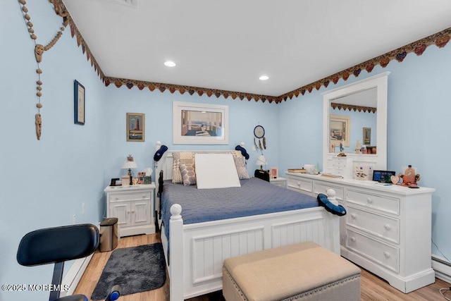 bedroom with light wood-style floors, recessed lighting, and baseboard heating