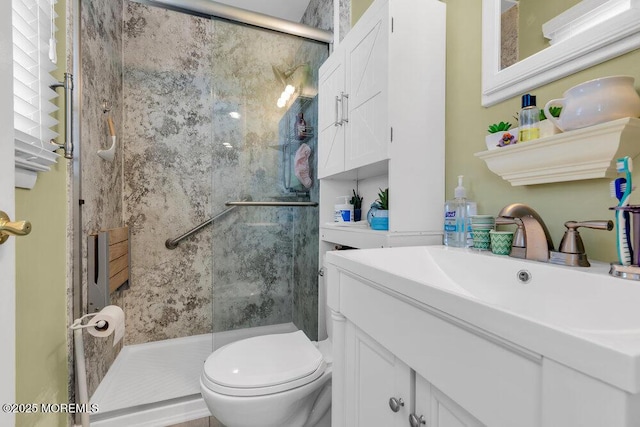 full bathroom with toilet, a stall shower, and vanity