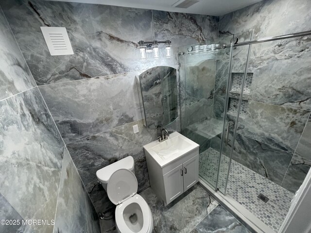 bathroom with toilet, marble finish floor, a marble finish shower, and vanity