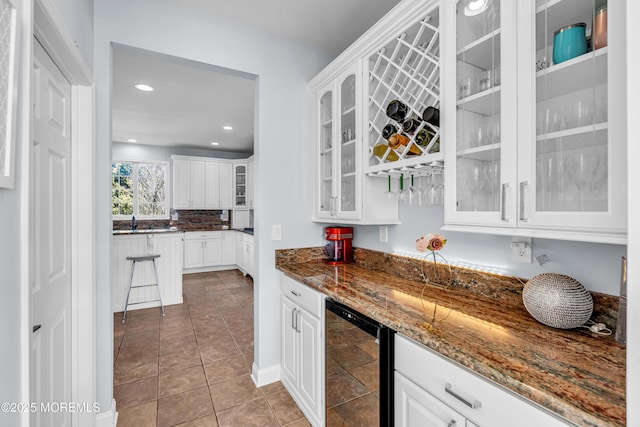 kitchen featuring light tile patterned floors, beverage cooler, dark stone counters, glass insert cabinets, and white cabinetry