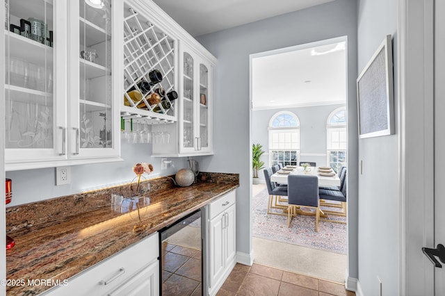 bar with wine cooler, tile patterned flooring, baseboards, a bar, and crown molding