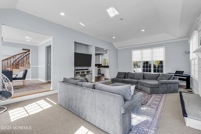 living area featuring vaulted ceiling, crown molding, stairway, and baseboards