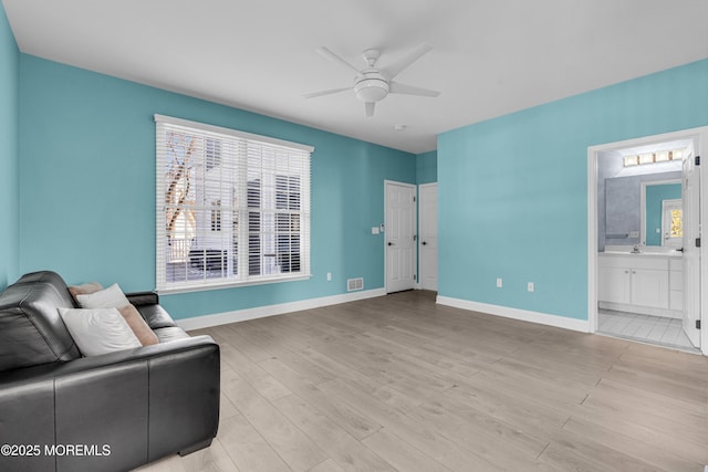 unfurnished room featuring visible vents, wood finished floors, a ceiling fan, and baseboards