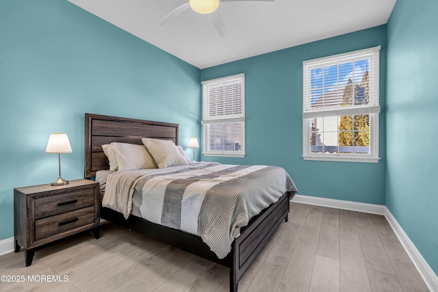 bedroom featuring light wood-type flooring, a ceiling fan, and baseboards