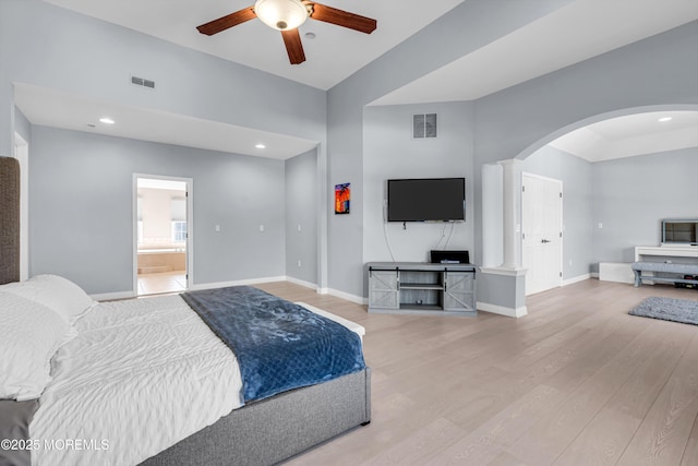 bedroom featuring arched walkways, baseboards, visible vents, and light wood finished floors