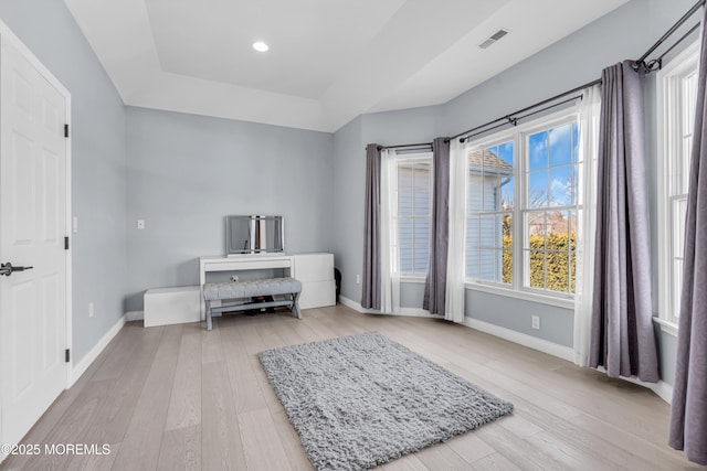 living area featuring recessed lighting, a raised ceiling, visible vents, light wood-type flooring, and baseboards