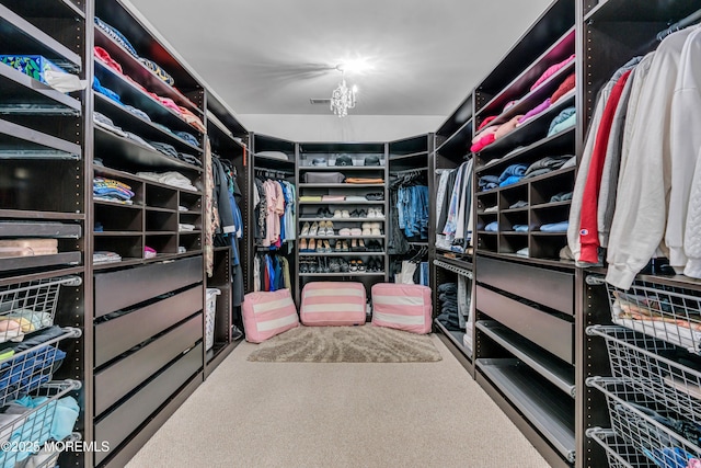 walk in closet featuring a notable chandelier