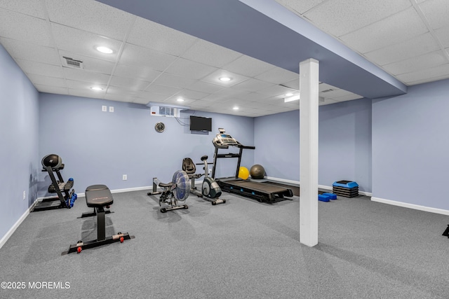 exercise area featuring a paneled ceiling, visible vents, and baseboards