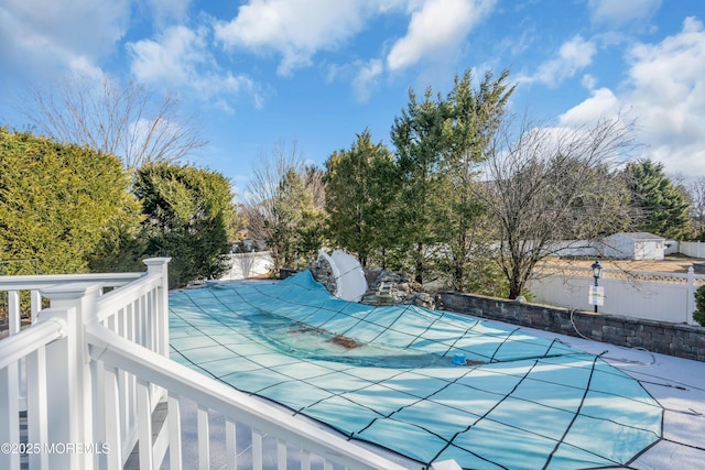 view of swimming pool featuring fence