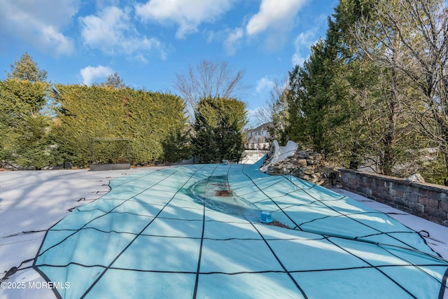 view of swimming pool featuring a patio and a covered pool