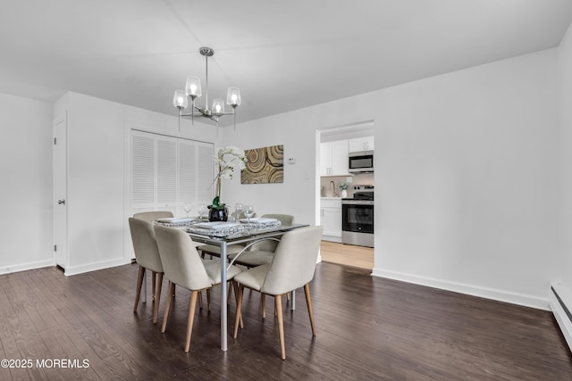 dining space featuring dark wood finished floors, baseboards, and an inviting chandelier