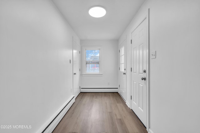 doorway to outside with light wood-style flooring, baseboards, and baseboard heating