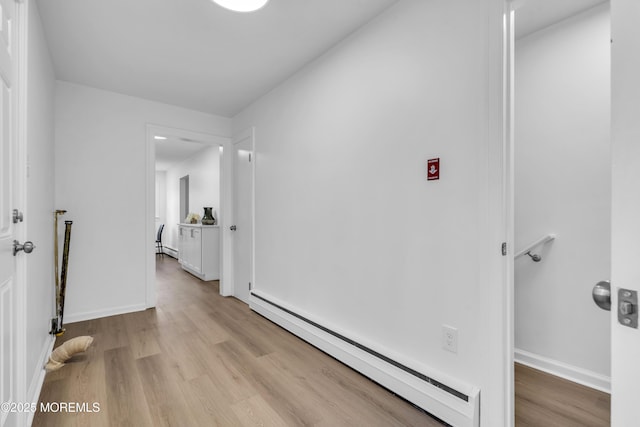 hall featuring light wood-style floors, baseboards, and baseboard heating