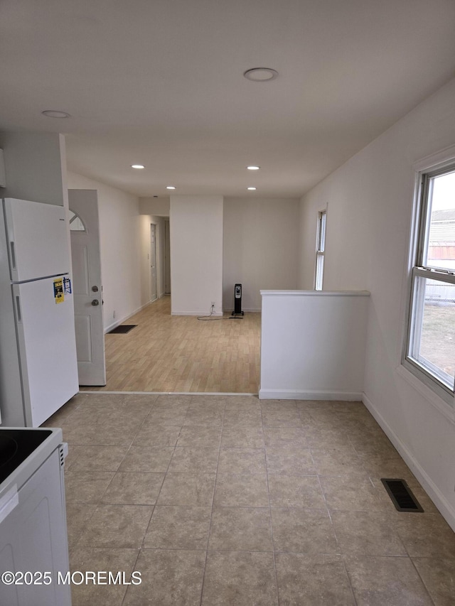 empty room featuring light tile patterned flooring, baseboards, visible vents, and recessed lighting