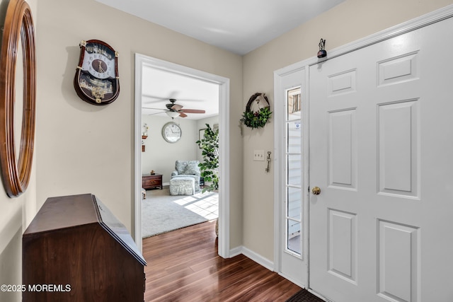 foyer with dark wood-style floors, ceiling fan, and baseboards