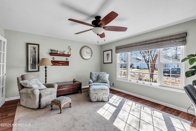 living area with ceiling fan, baseboards, and dark wood-style flooring