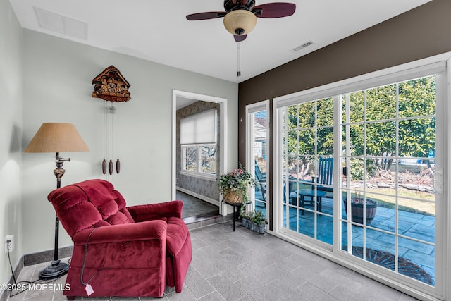 sitting room with ceiling fan, visible vents, and baseboards