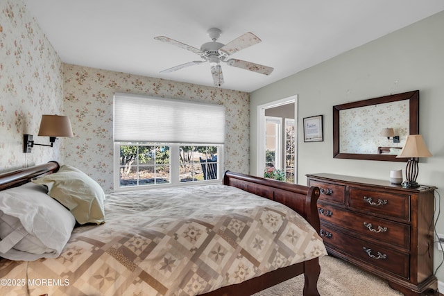 bedroom featuring light carpet, wallpapered walls, and a ceiling fan