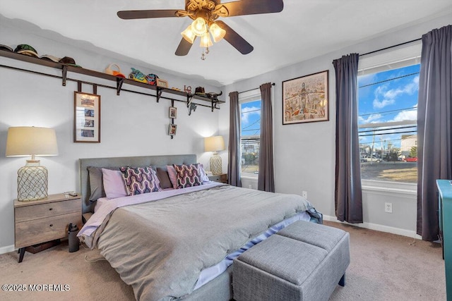 bedroom with light carpet, ceiling fan, and baseboards