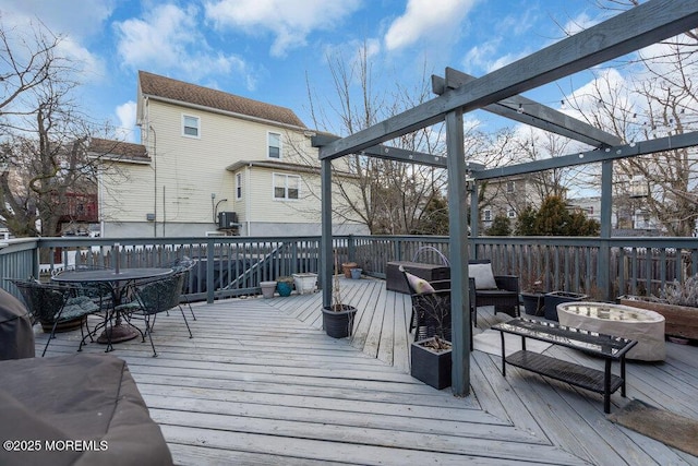 deck featuring outdoor dining space and a fire pit