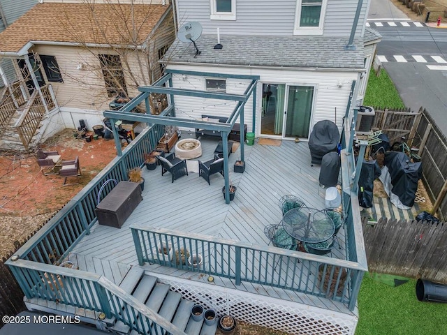 wooden terrace with an outdoor fire pit and fence