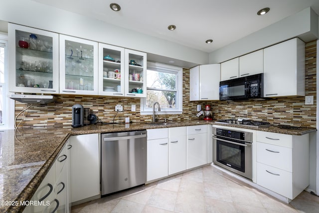 kitchen featuring white cabinetry, decorative backsplash, stainless steel appliances, and a sink