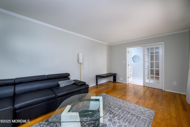 living area featuring ornamental molding, baseboards, and wood finished floors