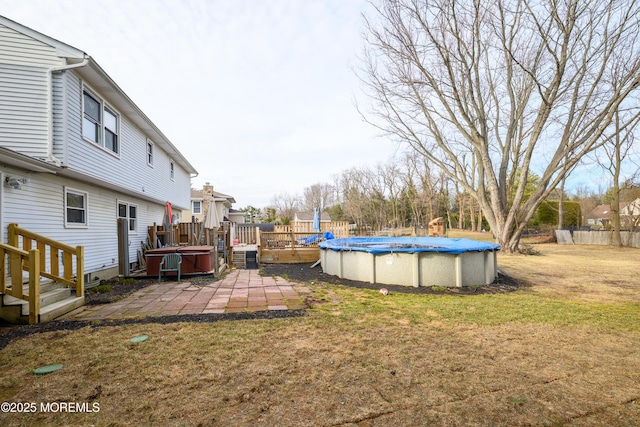 view of yard with central AC, a deck, a fenced in pool, and a patio