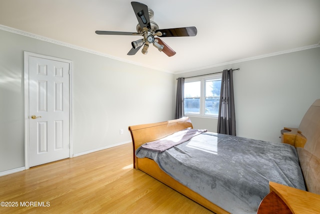 bedroom with light wood finished floors, a ceiling fan, baseboards, and crown molding