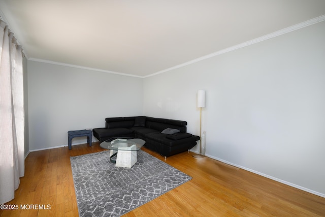 living room featuring ornamental molding, baseboards, and wood finished floors