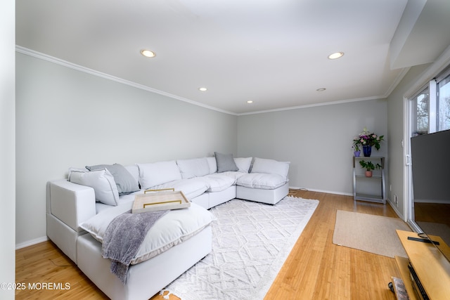 living area featuring light wood finished floors, baseboards, crown molding, and recessed lighting