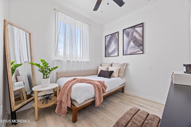 bedroom with light wood finished floors, a ceiling fan, baseboards, and crown molding