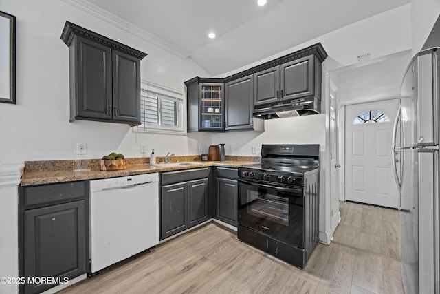 kitchen featuring freestanding refrigerator, a sink, black range, dishwasher, and under cabinet range hood