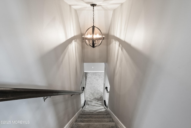 stairway featuring carpet floors, a chandelier, and baseboards