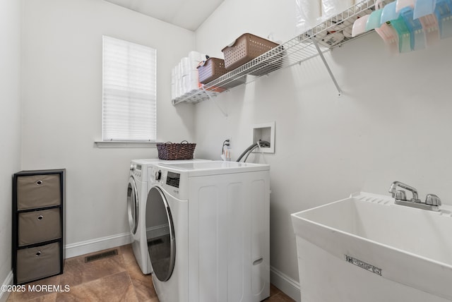 laundry area with washing machine and dryer, laundry area, a sink, visible vents, and baseboards