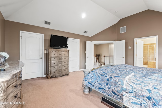 carpeted bedroom with visible vents, vaulted ceiling, and ensuite bath