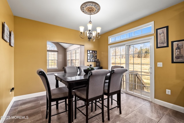 dining area featuring a chandelier, tile patterned floors, and baseboards