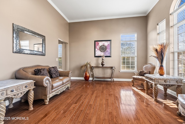 living area featuring ornamental molding, baseboards, and hardwood / wood-style floors