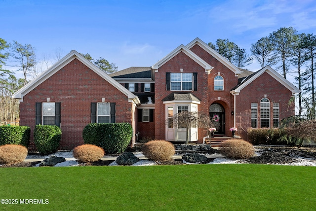 traditional-style home with a front yard and brick siding