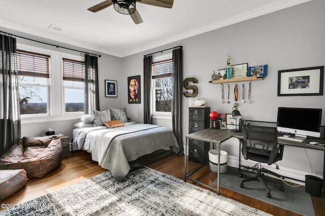 bedroom featuring multiple windows, wood finished floors, visible vents, and crown molding