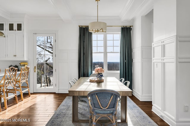 dining room with dark wood-style flooring, crown molding, a decorative wall, wainscoting, and beamed ceiling