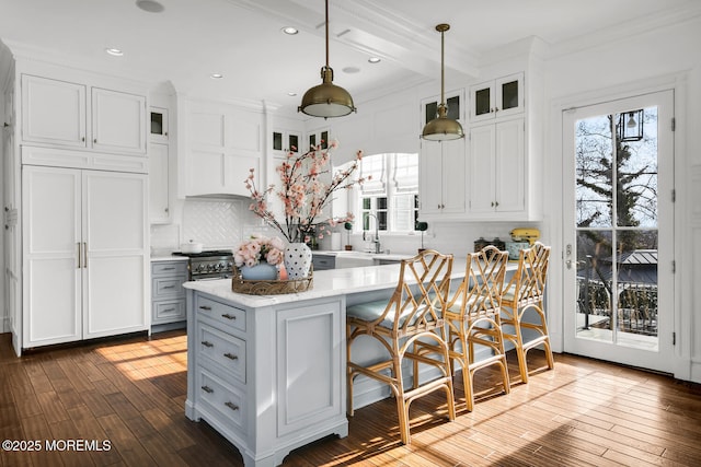 kitchen with white cabinets, dark wood-style floors, light countertops, and a wealth of natural light