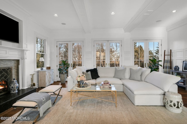 sunroom with a lit fireplace, beamed ceiling, and french doors