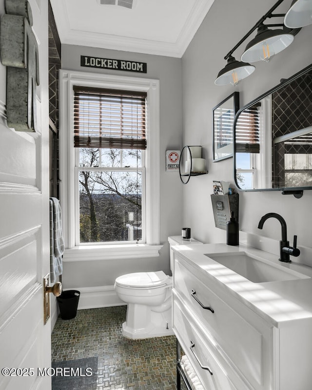 bathroom with visible vents, toilet, ornamental molding, vanity, and baseboards