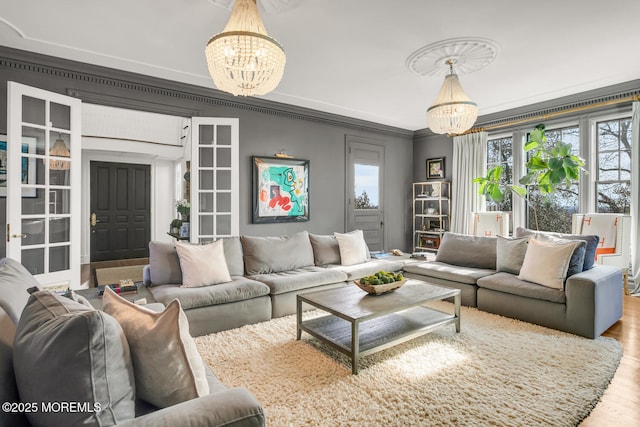 living area featuring a chandelier, crown molding, and wood finished floors