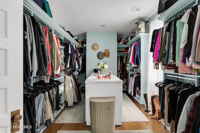 walk in closet with light wood-style flooring