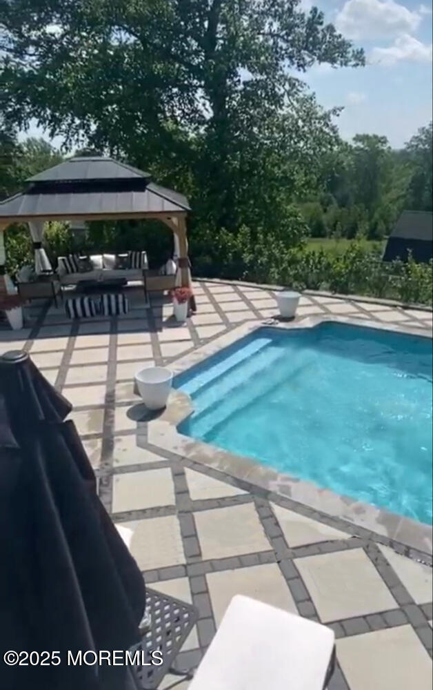 view of swimming pool featuring a gazebo and a patio